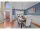 Dining room featuring blue walls, wainscoting, an elegant chandelier, and a wood dining table at 321 Nortwick Rd, Rolesville, NC 27571