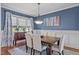 Dining room featuring blue walls, wainscoting, an elegant chandelier, and a wood dining table at 321 Nortwick Rd, Rolesville, NC 27571