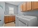 A laundry room with tile floors, a sink, and a washer and dryer with laundry cabinets overhead at 321 Nortwick Rd, Rolesville, NC 27571