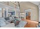 A living room with high ceilings, a large sectional couch, hardwood floors, and a view of the kitchen and dining area at 321 Nortwick Rd, Rolesville, NC 27571
