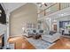 A living room with high ceilings, a fireplace, hardwood floors, a large sectional couch, and a stairway at 321 Nortwick Rd, Rolesville, NC 27571