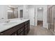 Modern bathroom with double sinks, a glass-enclosed shower, and neutral tile flooring at 3231 Pelican Ln, Durham, NC 27703