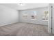 Bright bedroom featuring three windows, neutral walls and carpet flooring, offering a serene and comfortable space at 3231 Pelican Ln, Durham, NC 27703