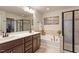 Bright bathroom featuring double sinks, soaking tub with tile surround, and a glass enclosed shower at 3422 Norway Spruce Rd, Raleigh, NC 27616