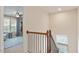 Hallway with wooden railing leading to upper floors and a patterned rug at 3422 Norway Spruce Rd, Raleigh, NC 27616