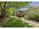 Spacious backyard with lush landscaping, a pergola-covered deck, and a stone path at 3519 Streams Of Fields Dr, Raleigh, NC 27604