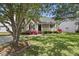 Inviting single-story home features a cozy front porch surrounded by lush greenery and vibrant azalea bushes at 3519 Streams Of Fields Dr, Raleigh, NC 27604