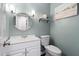 Cozy half bathroom featuring a vanity, a round mirror, and decorative wall accents at 3805 Euliss Rd, Burlington, NC 27215