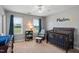 Charming bedroom with natural light, rocking chair, and a dark wood crib at 3805 Euliss Rd, Burlington, NC 27215