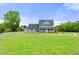 Two-story home on a large grassy lot, featuring a welcoming front porch and ample space for outdoor activities at 3805 Euliss Rd, Burlington, NC 27215