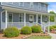 Inviting front porch with white railings, flower boxes, and manicured shrubs at a charming home at 3805 Euliss Rd, Burlington, NC 27215
