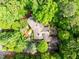 Aerial view showing the home with a large stone patio in a mature and private wooded lot at 3915 Nottaway Rd, Durham, NC 27707