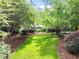 Expansive backyard features a meticulously manicured lawn and landscaping with a variety of trees and plants at 3915 Nottaway Rd, Durham, NC 27707