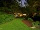 Picturesque backyard with manicured lawn, landscape lighting and lush greenery at 3915 Nottaway Rd, Durham, NC 27707