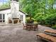 Charming backyard features an outdoor fireplace and brick patio with seating, perfect for entertaining or relaxing at 3915 Nottaway Rd, Durham, NC 27707
