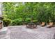 A brick patio with outdoor seating surrounded by lush greenery and a brick fireplace at 3915 Nottaway Rd, Durham, NC 27707