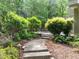 Stone steps lead through lush foliage to the patio and backyard at 3915 Nottaway Rd, Durham, NC 27707