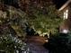 Evening view of a landscaped backyard with a stone pathway and tasteful landscape lighting at 3915 Nottaway Rd, Durham, NC 27707