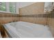 Close-up of a bathtub with tile detailing and integrated jets at 3915 Nottaway Rd, Durham, NC 27707
