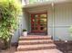 Inviting front entrance with a brick staircase, double doors with windows, and a well-maintained landscape at 3915 Nottaway Rd, Durham, NC 27707