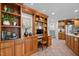 Open kitchen featuring built-in desk, wood cabinets, stainless steel appliances, and tiled flooring at 3915 Nottaway Rd, Durham, NC 27707