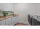 Bright laundry room with white cabinets, a utility sink, and modern washer and dryer at 3915 Nottaway Rd, Durham, NC 27707