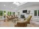 Bright living room featuring a skylight, fireplace, comfortable seating, and stylish decor at 3915 Nottaway Rd, Durham, NC 27707