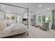 Bright main bedroom with canopy bed, sitting area, large windows, and neutral decor at 3915 Nottaway Rd, Durham, NC 27707