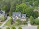 Stunning aerial view showcases this yellow two-story home nestled among lush green trees at 402 Troycott Pl, Cary, NC 27519