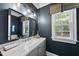 Updated bathroom with a gray vanity, granite countertop, and a large mirror at 402 Troycott Pl, Cary, NC 27519