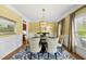 Dining room featuring stylish chairs, an eye-catching light fixture, and soft yellow walls, creating a warm ambiance at 402 Troycott Pl, Cary, NC 27519