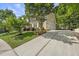 Well-manicured yellow home with a 3-car garage, mature trees, and a long concrete driveway at 402 Troycott Pl, Cary, NC 27519