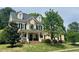 Charming two-story home featuring a welcoming front porch, well-manicured lawn, and beautiful landscaping at 402 Troycott Pl, Cary, NC 27519