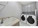 Functional laundry room with modern washer and dryer, sink, and ample storage cabinets at 402 Troycott Pl, Cary, NC 27519