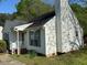 Close view of the home's siding, windows with dark shutters, and lush shrubbery in the front yard at 409 Vista Springs Cir, Holly Springs, NC 27540