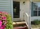 Close-up highlighting the front door, vibrant flowering shrubbery, and neat landscaping at 409 Vista Springs Cir, Holly Springs, NC 27540