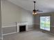 Open living room with a fireplace and window providing abundant natural light at 409 Vista Springs Cir, Holly Springs, NC 27540
