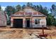 Exterior view of a house under construction with a two-car garage, awaiting its final touches and landscaping at 41 Goldenrod Loop, Clayton, NC 27520