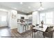 Bright eat-in kitchen boasts an island with a granite countertop, seating, stainless steel appliances, and white cabinets at 41 Goldenrod Loop, Clayton, NC 27520