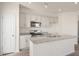 Bright kitchen featuring white cabinets, stainless appliances, a granite-topped island, and wood-look floors at 420 Ember St, Sanford, NC 27330