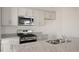 Bright kitchen featuring granite countertops, stainless steel appliances, and shaker style cabinets at 420 Ember St, Sanford, NC 27330