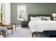 Well-lit bedroom featuring an accent wall, seating, and a comfortable bed to showcase a relaxing space at 4215 Cobscook Dr, Durham, NC 27707