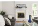 Cozy living room fireplace with white brick surround, mantel decorations, and a comfortable seating area at 4215 Cobscook Dr, Durham, NC 27707
