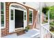 Inviting front porch with a dark door, white trim, brick accents, and a hanging fern for added charm at 4215 Cobscook Dr, Durham, NC 27707