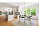 Bright kitchen and dining area with white cabinets, hardwood floors, and ample natural light at 4215 Cobscook Dr, Durham, NC 27707