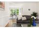Comfortable living room offering hardwood floors, white trim, modern furniture, and a glimpse into the dining area at 4215 Cobscook Dr, Durham, NC 27707
