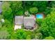 Stunning aerial view of a home with a pool, fire pit, and lush green landscaping surrounded by mature trees at 4405 New Brighton Dr, Apex, NC 27539