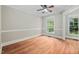 Light-filled bedroom with hardwood floors, ceiling fan, and bright window at 4405 New Brighton Dr, Apex, NC 27539
