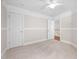 Bright bedroom featuring plush carpeting, ceiling fan, and two closets at 4405 New Brighton Dr, Apex, NC 27539