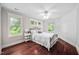 Cozy bedroom with hardwood floors, two windows, and a ceiling fan at 4405 New Brighton Dr, Apex, NC 27539